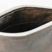 A brown luxury leather alternative interior with a gold seam on the inside of a makeup bag