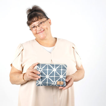Woman holding blue and white geometric patterned pouch named Erica 