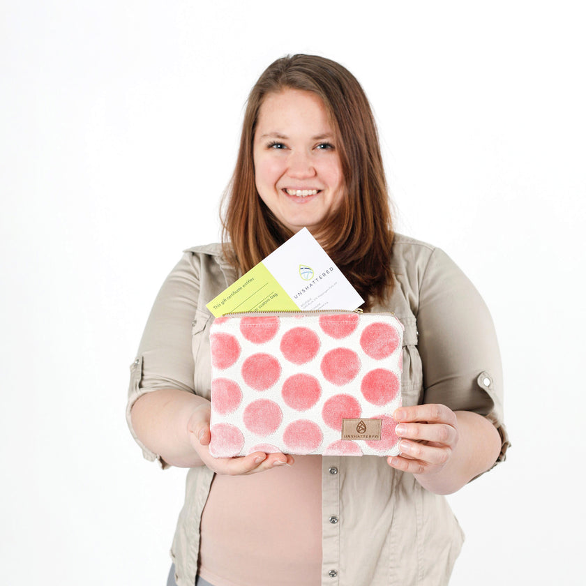 Woman holding a pink polka dot clutch with a white background