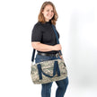 Woman holding a camo duffle made from upcycled US Airforce uniforms with blue cotton straps