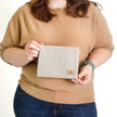 Woman holding a checkered pouch  named after Kara 