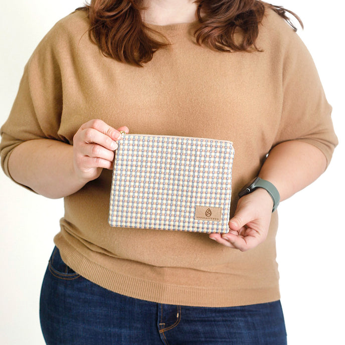 Woman holding a checkered pouch  named after Kara 
