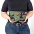 A woman holds a makeup bag handcrafted from upcycled woodland camouflage uniforms with a brown label and gold tone zipper