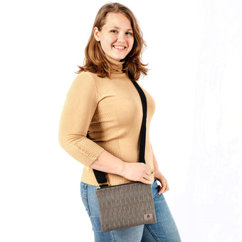 Woman holding a textured gray crossbody pouch on a white background