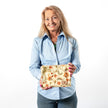 Woman holding a floral-patterned zip pouch on a white background