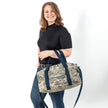 Woman holding a camo duffle bag made from upcycled US Airforce uniforms