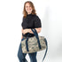 Woman holding a camo duffle bag made from upcycled US Airforce uniforms