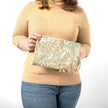 Person holding a paisley patterned zippered pouch against a white background