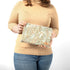 Person holding a paisley patterned zippered pouch against a white background