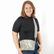 A woman wearing a errand bag handcrafted from upcycled digital camo army uniform with an adjustable strap and a front zippered pocket 
