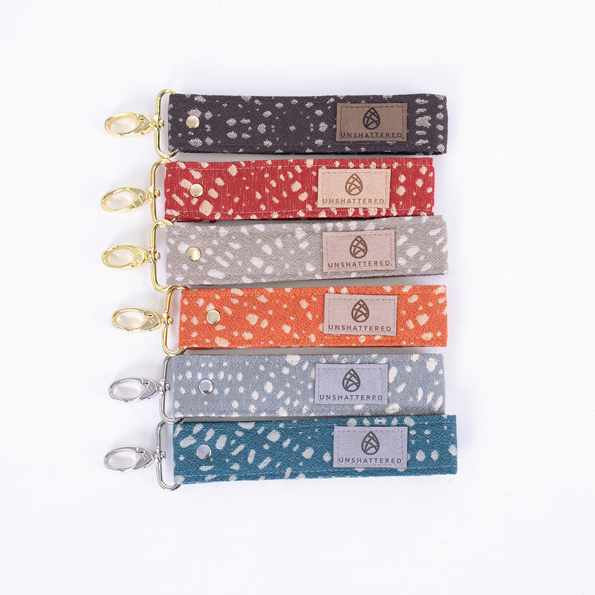 Stylish and practical fabric wristlet key clip featuring a dotted pattern and elegant gold/silver-tone hardware.