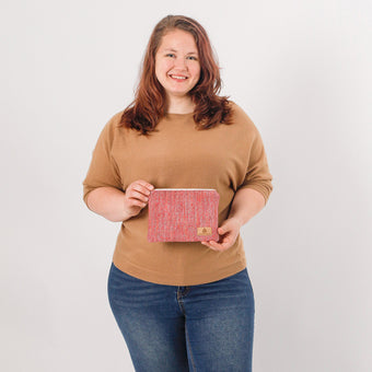 Woman holding a pink zip pouch against a white background