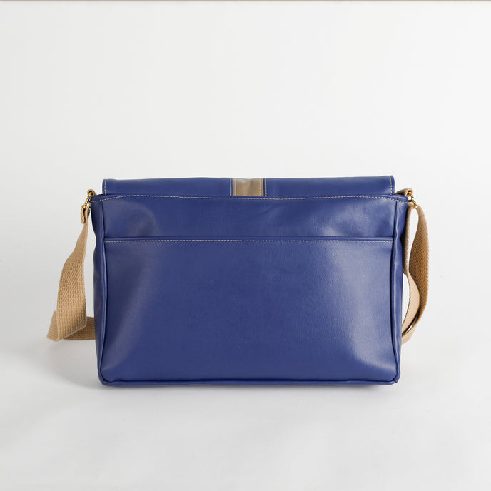 Blue Southwest leather bag with beige strap on a light gray background