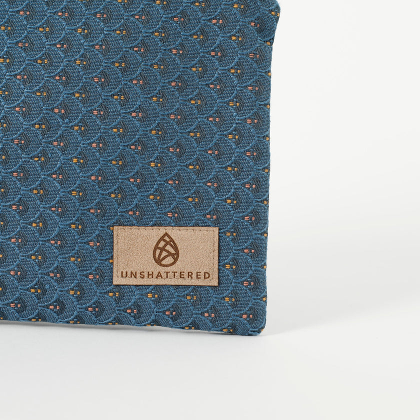 A tan label on a blue zip pouch with shells design