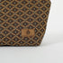 Close up of a brown, ultrasuede Unshattered label on a makeup bag with a brown and blue geometric pattern