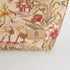 Fabric with floral and bird pattern and 'Unshattered' brand label on a white background named after Anitha 