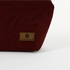 A brown label on a burgundy makeup bag named after Alaney 