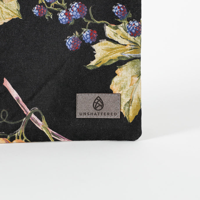 A dark gray label on the corner of a fruit design large zip pouch 