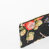A gold toned zipper on a black fruit design fabric large zip pouch named after Diane