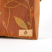 Brown fabric with leaf patterns and 'Unshattered' brand label on a white background named after Nita 