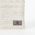 A gray label on a two toned twill weave zip pouch named after Sharon 