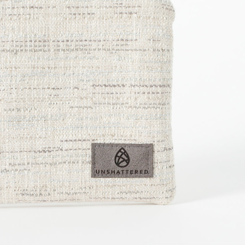 A gray label on a two toned twill weave zip pouch named after Sharon 
