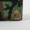 A brown label on the right corner of a woodland camo errand 