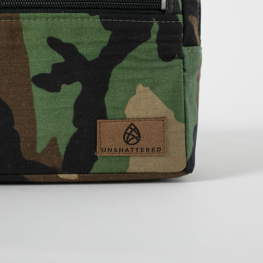 A brown label on the right corner of a woodland camo errand 