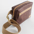 Brown errand bag with gold-tone zipper and tan cotton strap on a white background