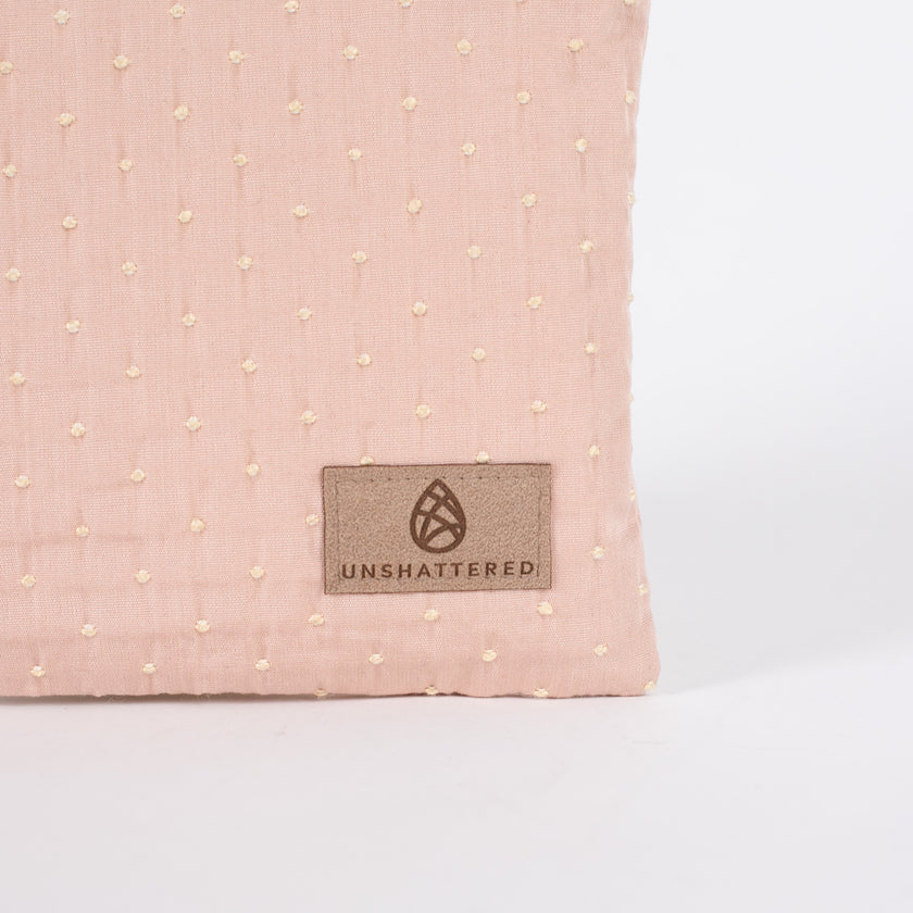 detail shot of the tan label on this pink and yellow zip pouch named after Susan 