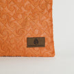 Orange textured fabric with a brand label on a light gray background named after Grace 