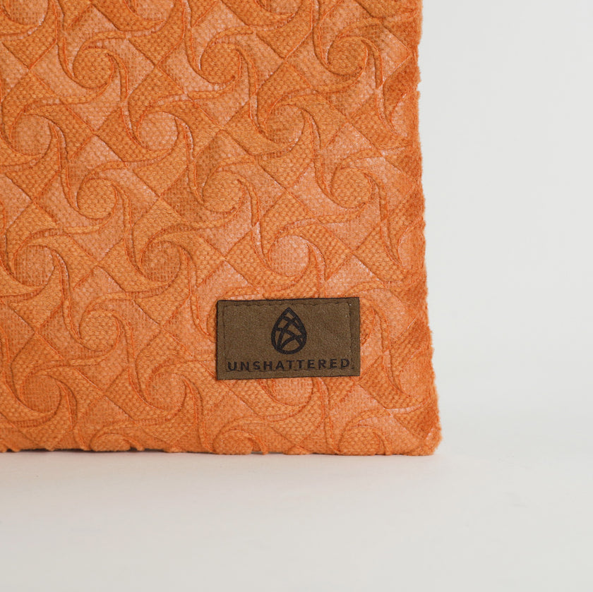 Orange textured fabric with a brand label on a light gray background named after Grace 