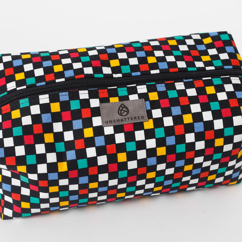 Colorful checkered pouch with 'Unshattered' brand logo on a white background named after Lyddin 