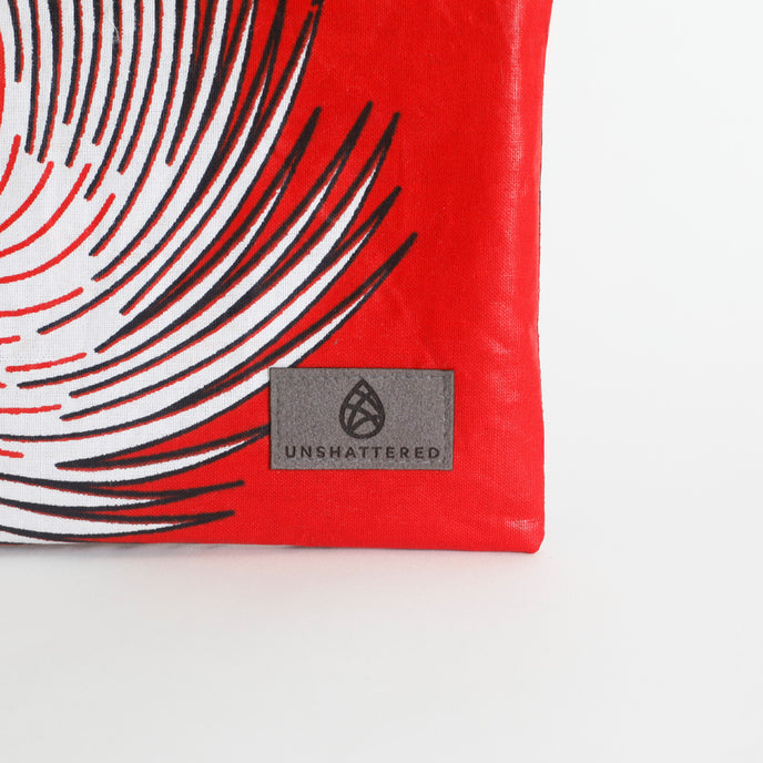 Red pouch with black and white abstract design and 'Unshattered' brand logo on a white background named after Aiyannah 