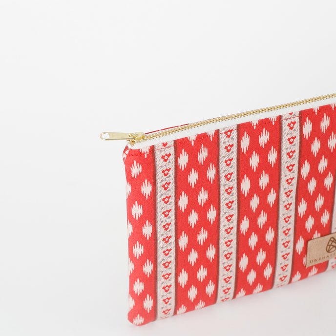 Red and white patterned pouch with gold zipper on a white background name after Neena 