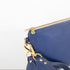 A detail zipper shot of the tan zipper and Unshattered emblem.