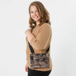 A woman carrying a cafe fabric crossbody pouch with gold hardware and a black strap 