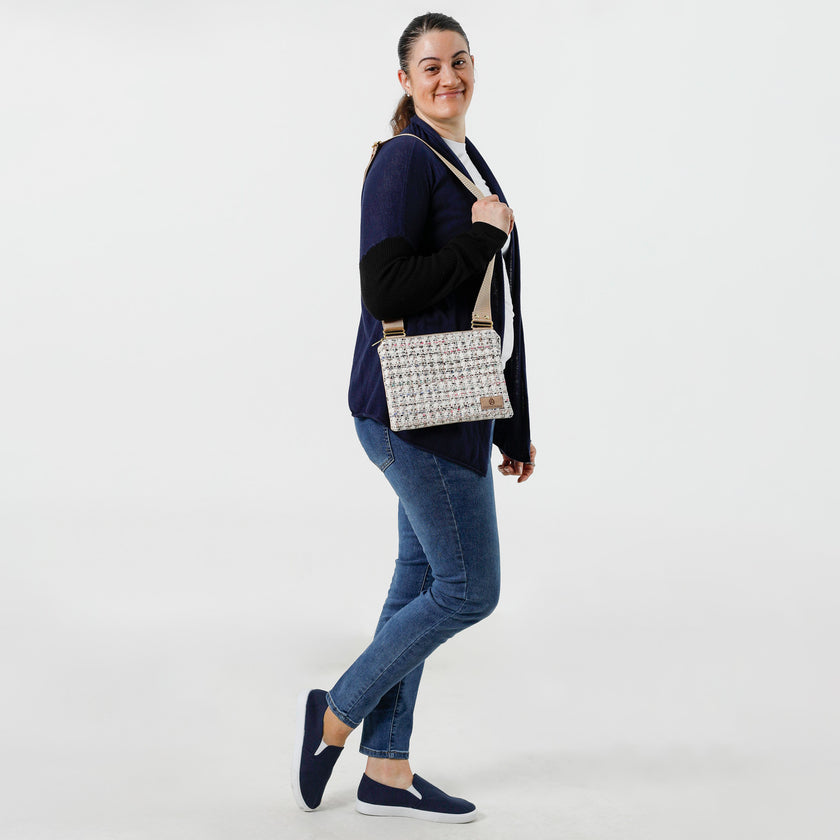 A woman wearing this multi-color tweed crossbody with a tan label named after Lydia