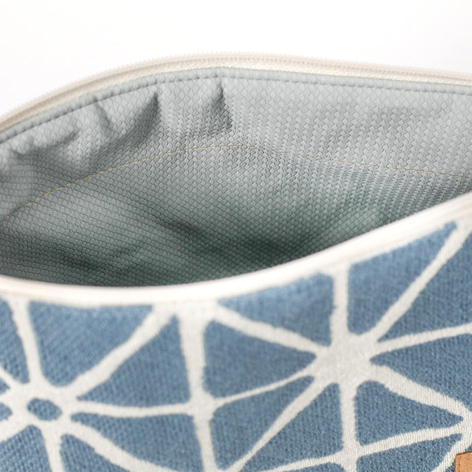 Light blue wipe-clean interior of a blue geometric patterned makeup bag named Erin