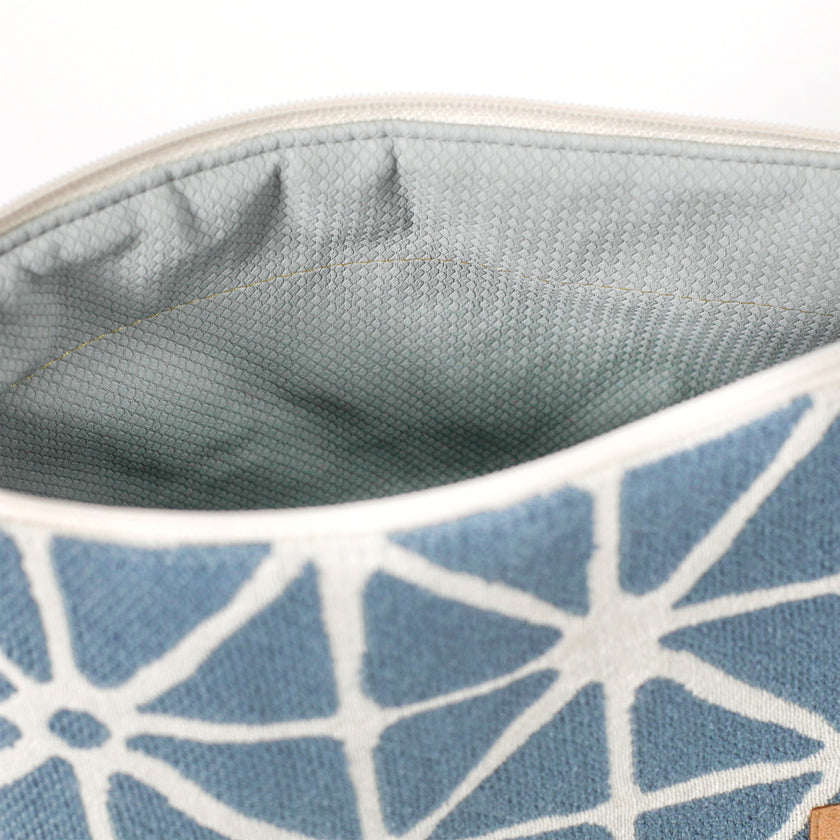 Light blue wipe-clean interior of a blue geometric patterned makeup bag named Erin