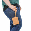a woman carrying a camel luxury leather alternative clip pouch named after Rashida
