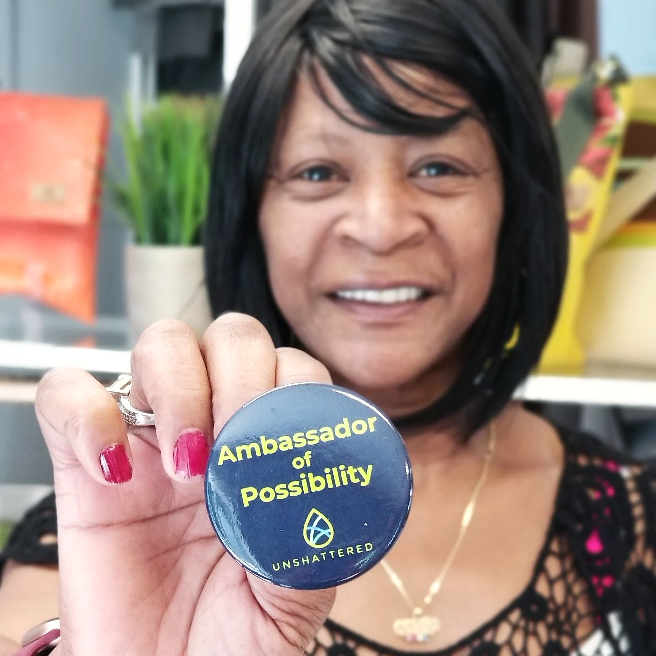 One Ambassador of Possibility button held by a woman.